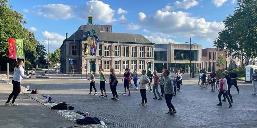 Een groep mensen danst op de Bist onder begeleiding van een docent van Huys Arts